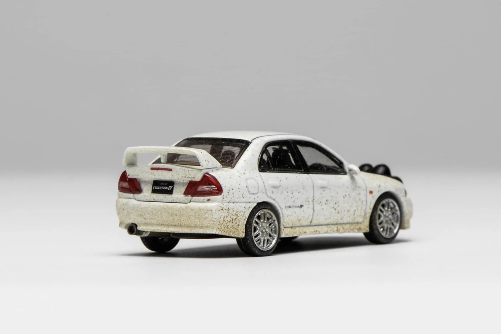 MotorHelix 1:64 Mitsubishi Lancer EVO IV Muddy Version in Rally White - Image 3